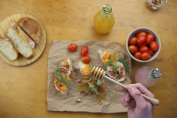 cooking Italian dish. bruschetta. in the photo, hands are preparing a dish of bread, herbs, jamon, cheese and honey. home-cooked lunch and dinner