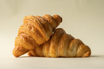 freshly baked croissants in a colored background, green, black, or neutral. with fresh flowers newspaper, cappuccino showing layers and crumbles and filling with berries