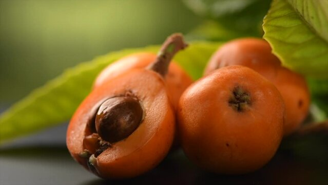 Loquat fruit or Japanese medlars, Nispero, Eriobotrya japonica fresh ripe bio vegetarian food, loquats, medlar berries. Close up, slow motion. 