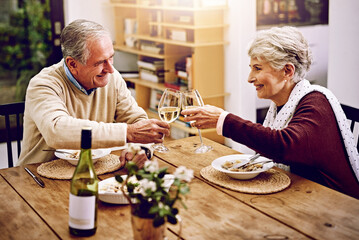 Senior couple, wine and cheers on table to celebrate anniversary, dinner or lunch at home. Happy,...