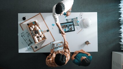 Top view of skilled architect engineer working together and shaking hand cooperative team while...