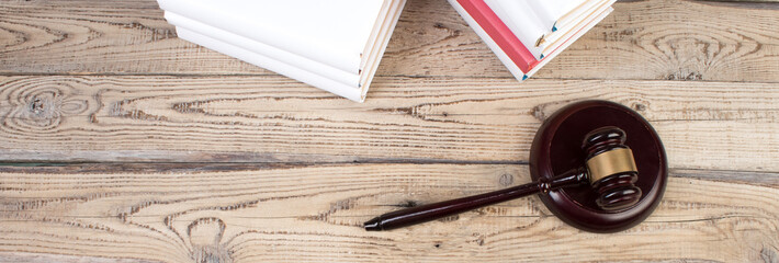 Law concept - Open law book with a wooden judges gavel on table in a courtroom or law enforcement office isolated on white background. panorama, banner.