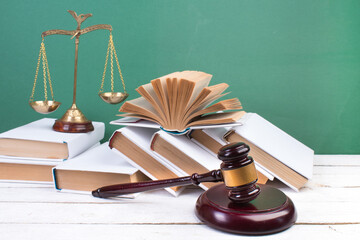 Law concept - Open law book, Judge's gavel, scales on table in a courtroom or law enforcement...