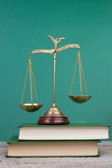 Law concept - Open law book, scales on table in a courtroom or law enforcement office.