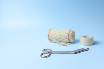 A pair of scissors and a roll of tape are on a blue background. Concept of preparedness and...