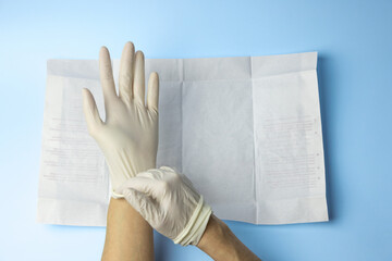 A person wearing gloves is holding a piece of paper