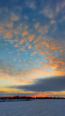 Sunset on the background of a snowy field