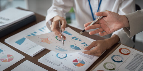 Businesswomen analyzing financial data and charts with calculator in office meeting