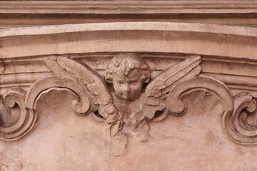 Sculpted Angel Head with Wings on the Frame of a Street Shrine in Rome, Italy