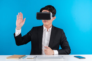 Asian businessman looking through VR connecting touchscreen hologram monitor in futuristic...
