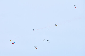 Airborne forces paratroopers soaring holding Flag of Russia and flags of military units, military exercise for celebration of Airborne Forces Day with formation landing, army airborne division descend