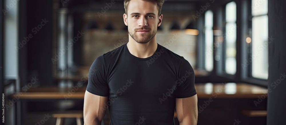 Poster A guy wearing a black T shirt poses for a portrait in a spacious room with a generous amount of natural light. Copyspace image