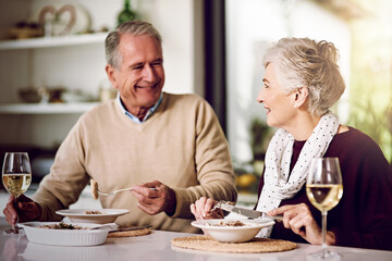 Senior, couple and dinner in home for anniversary, date or retirement with love in marriage. Elderly, people and eating together with wine drink and happy for romance, relationship or bonding