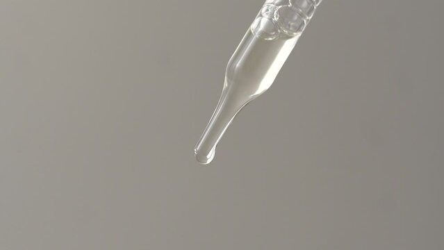 Macro video of dropper with transparent liquid.