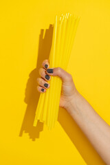 Hand holding bunch of plastic drinking straw