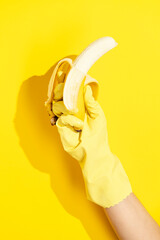 Hand wearing rubber gloves holding peeled banana