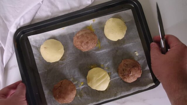 Cooking making mexican traditional conchas pastry, cookie or bread buns. Homemade preparation of conchas dessert pastry, on baking sheet with man hands in pic