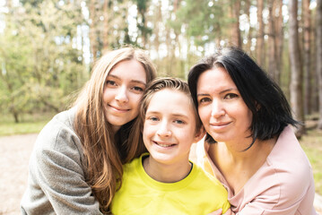 portrait of a happy 11 year old boy with his older sister and mom