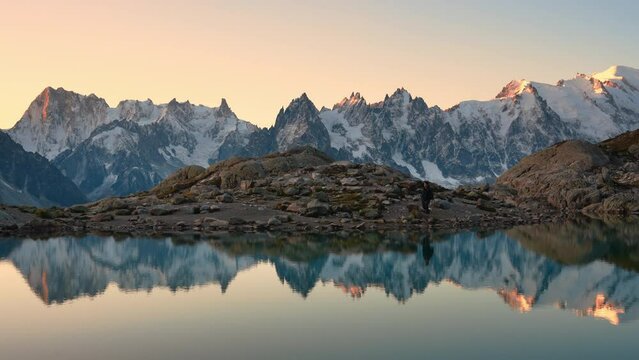 Landscape of Lac Blanc with Mont Blanc massif and male tourist reflect on the lake among French Alps in the morning at Chamonix Mont Blanc