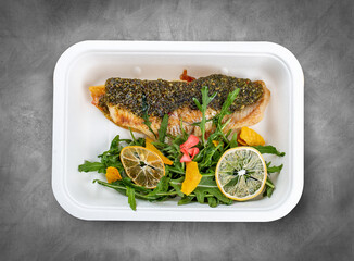 Hake with green beans and pesto sauce. Healthy diet. Takeaway food. Ecological packaging. Top view, on a gray background.