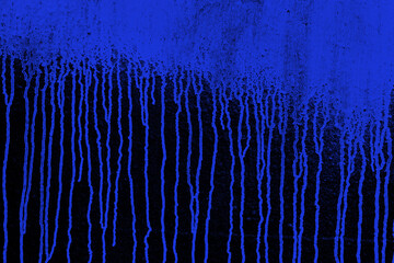 Blue paint running down the black wall