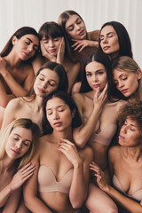 Obraz premium Vertical photo of girlfriends satisfying each other and sitting together in studio isolated on white color background