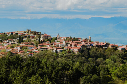 Signahi Signagi city town in Georgia. Sunny weather with clouds and mountains on a background. Roofs and houses on big hill. Travel in Sakartvelo, Georgia.