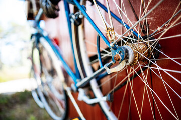 Rusty antique blue bike hanging on a red shed