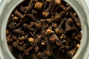 Photograph of cloves in a glass jar with daylight. Concept of natural ingredients
