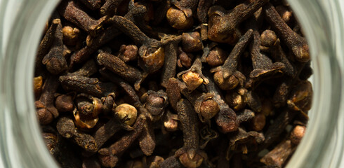 Photograph of cloves in a glass jar with daylight. Concept of natural ingredients