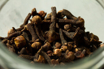 Photograph of cloves in a glass jar with daylight. Concept of natural ingredients
