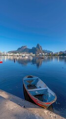 a serene lake beneath a clear blue sky, framed by distant mountains and buildings, with boats gently floating on the water.