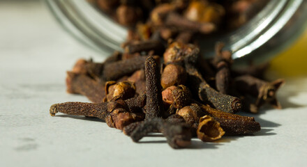 Photograph of cloves in a glass jar with daylight. Concept of natural ingredients