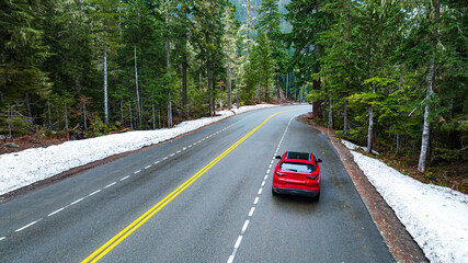 Obraz premium Beautiful natural wild landscape crossed by the speed highway. Car move by the roads in the mountainous area covered with pine tree forest. Aerial view.