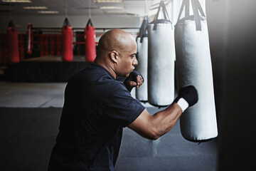 Exercise, punching bag and man in MMA gym for boxing, challenge or competition training. Power,...
