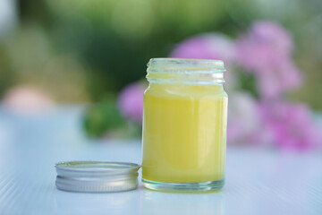 Bottle of homemade Thai herbal yellow ointment, balm.Decorated with  flower. Concept, Thai local wisdom to use fragrant medicinal herbs to make inhaler and massage balm.        