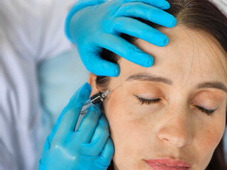 Cosmetic treatment and closeup hands of a cosmetologist making facial skin