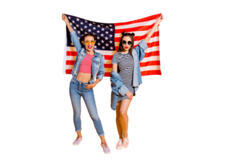 Full legs length body size portrait of two cool beautiful attractive pretty dreamy charming lovely cute sweet gorgeous tourist travel lady in glasses spectacles isolated yellow wall raised usa flag