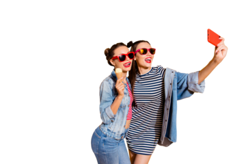 Two beautiful attractive brunette hair lady isolated on yellow background in street style stylish casual denim jeans trendy glasses spectacles take picture on cellular show tongue stick out
