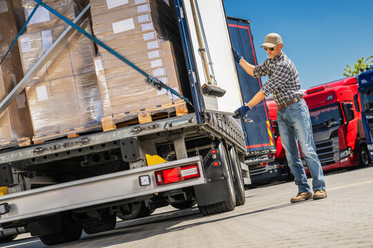 Trucker Loading Cargo Boxes Into Truck