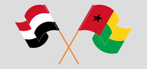 Crossed and waving flags of Yemen and Guinea-Bissau