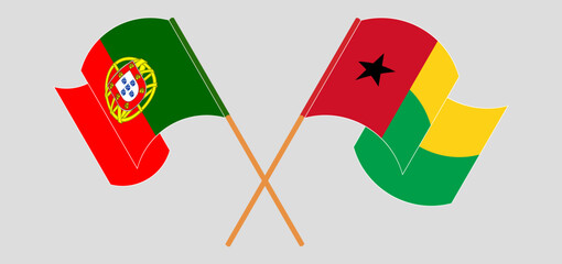 Crossed and waving flags of Portugal and Guinea-Bissau