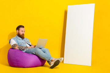 Photo of funny busy man wear jeans waistcoat sitting beanbag working modern device empty space...