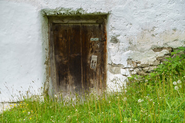 Eine alte dunkle Holztür in rustikalem Gemäuer als idealer Hintergrund