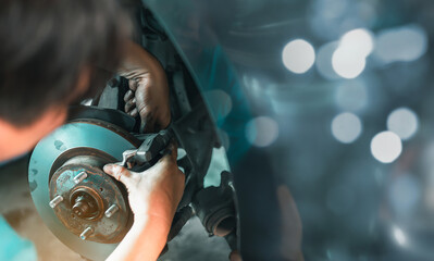 A skilled mechanic works meticulously on a car's brake disc in a garage, highlighting precision and...