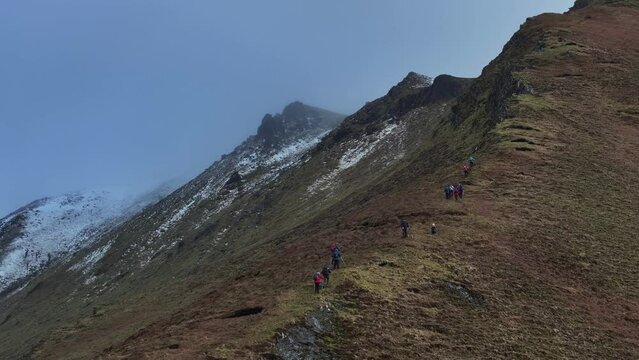Drone footage of hikers climbing snowy mountains in Dingle, Ireland 4K Mavic 3 Pro