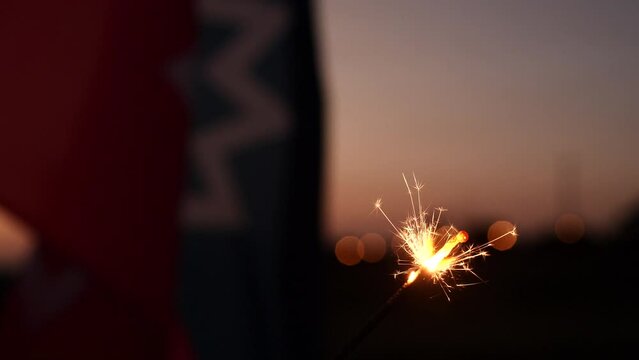 Celebration of Juneteenth freedom day with sparkler firework, Juneteenth flag waving at sunset. Concept of Celebration, Juneteenth, Independence Day, Freedom Day, African, American, Holiday, June 19