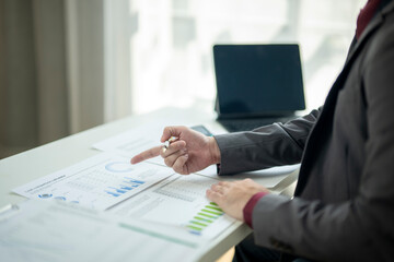 A man is pointing at a graph on a table
