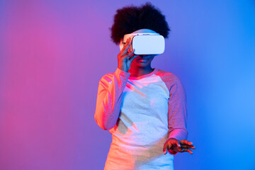 Young African wearing VR glasses through metaverse to select 3D hologram data application isolated...