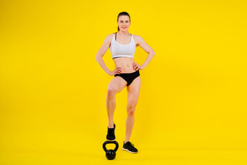 Attractive young athlete with muscular body exercising crossfit workout with kettlebell.